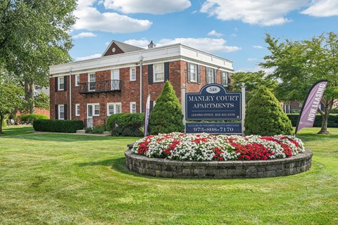 A sign in front of a building that says Manley Court Apartments.