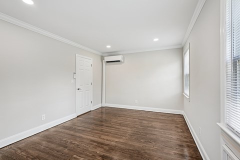 A room with a white door and a window with blinds.