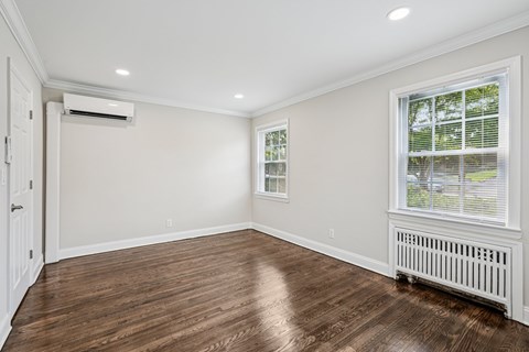 A room with a window and a radiator on the floor.