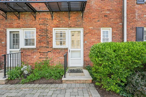 A red brick house with a white door and windows.