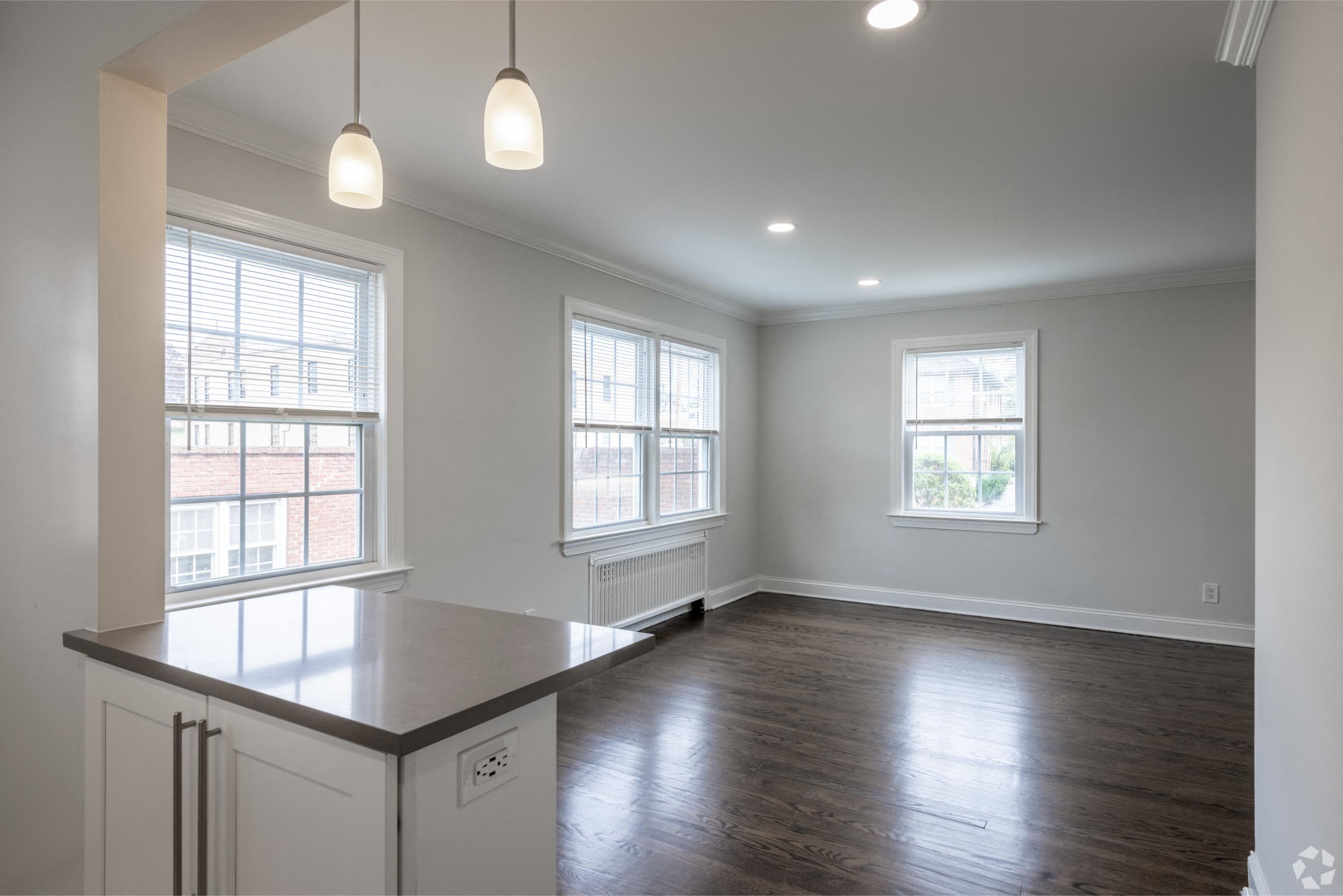 an empty kitchen with white cabinets and a counter top