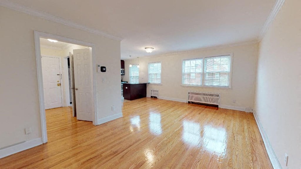 an empty living room with a hard wood floor