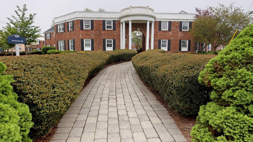 the front of a brick building with a pathway in front of it
