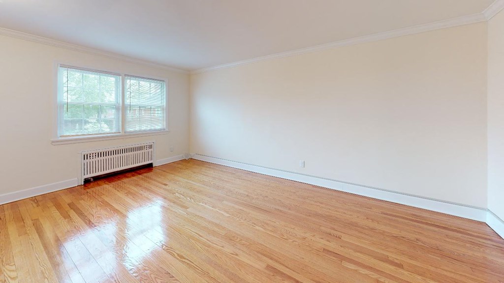 an empty living room with wood floors and a window