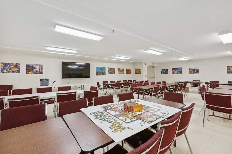 a conference room with tables and chairs and a television