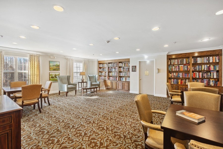 a library with chairs and tables and bookshelves