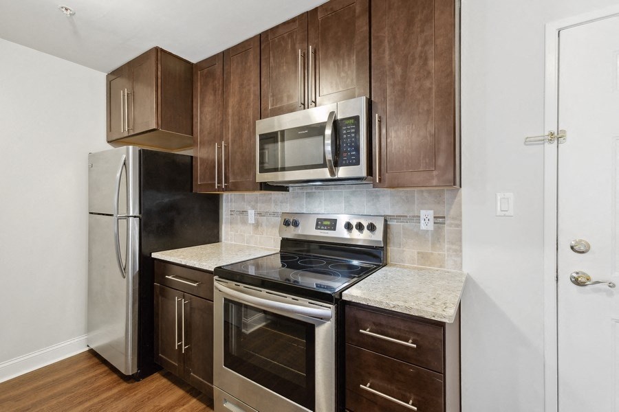 a kitchen with wooden cabinets and stainless steel appliances