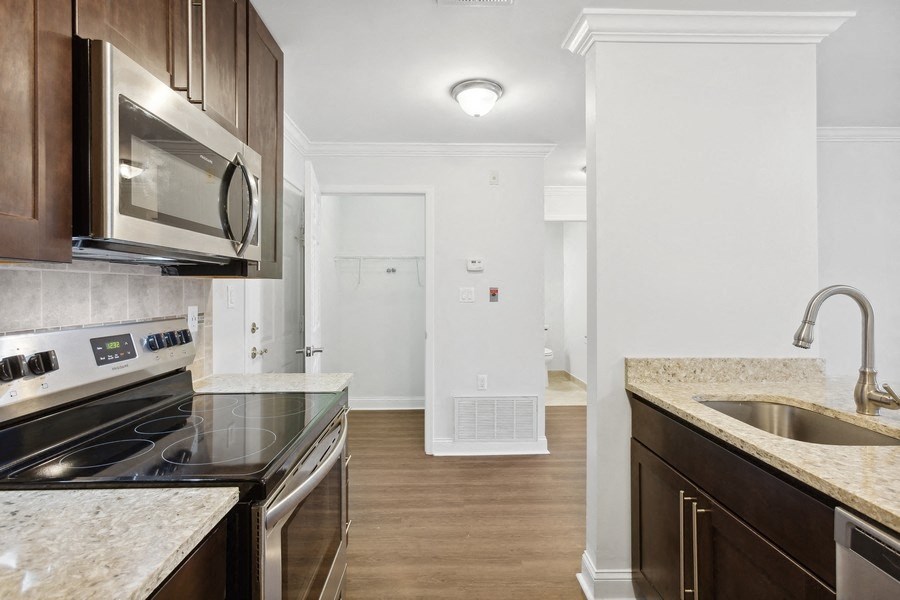 a renovated kitchen with granite counter tops and stainless steel appliances