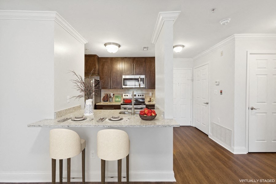 a kitchen with white cabinets and a marble counter top