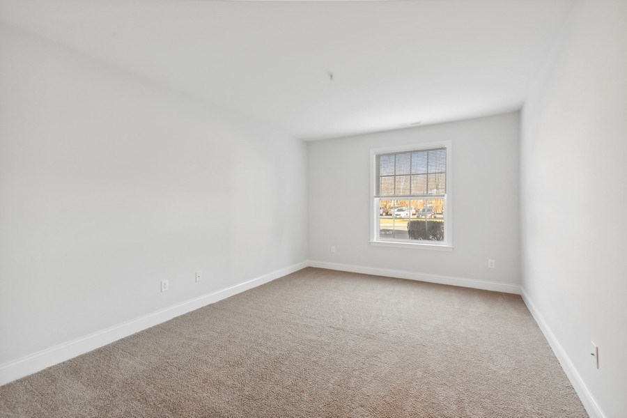 an empty room with white walls and a window