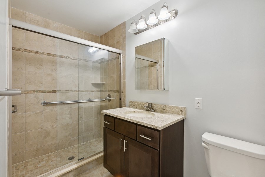 a bathroom with a large shower and a sink and a toilet
