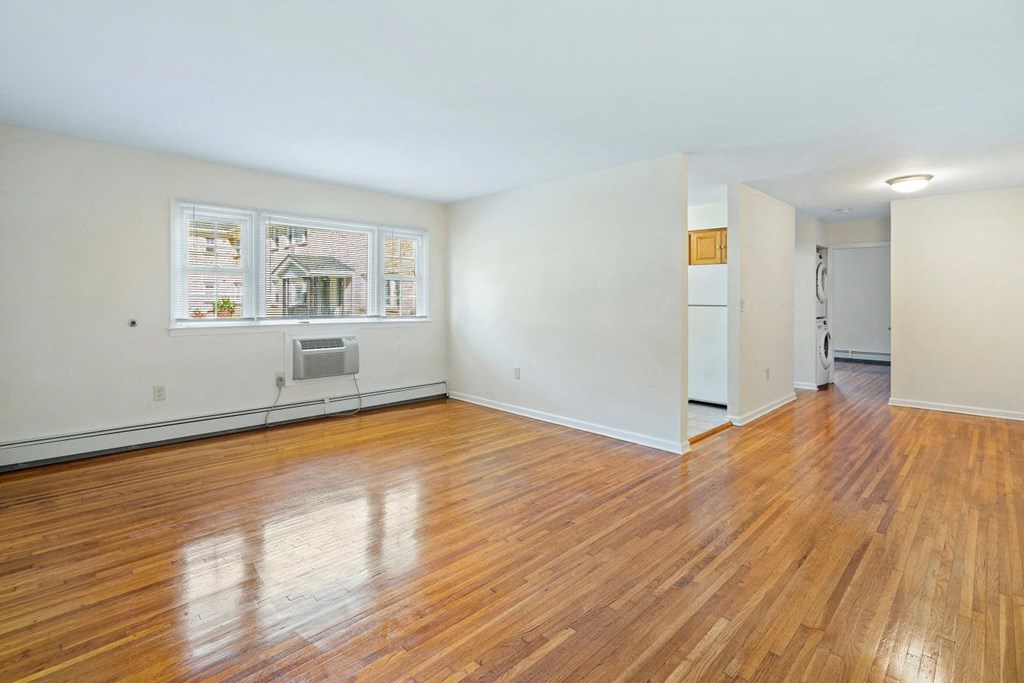an empty living room with wood floors and white walls