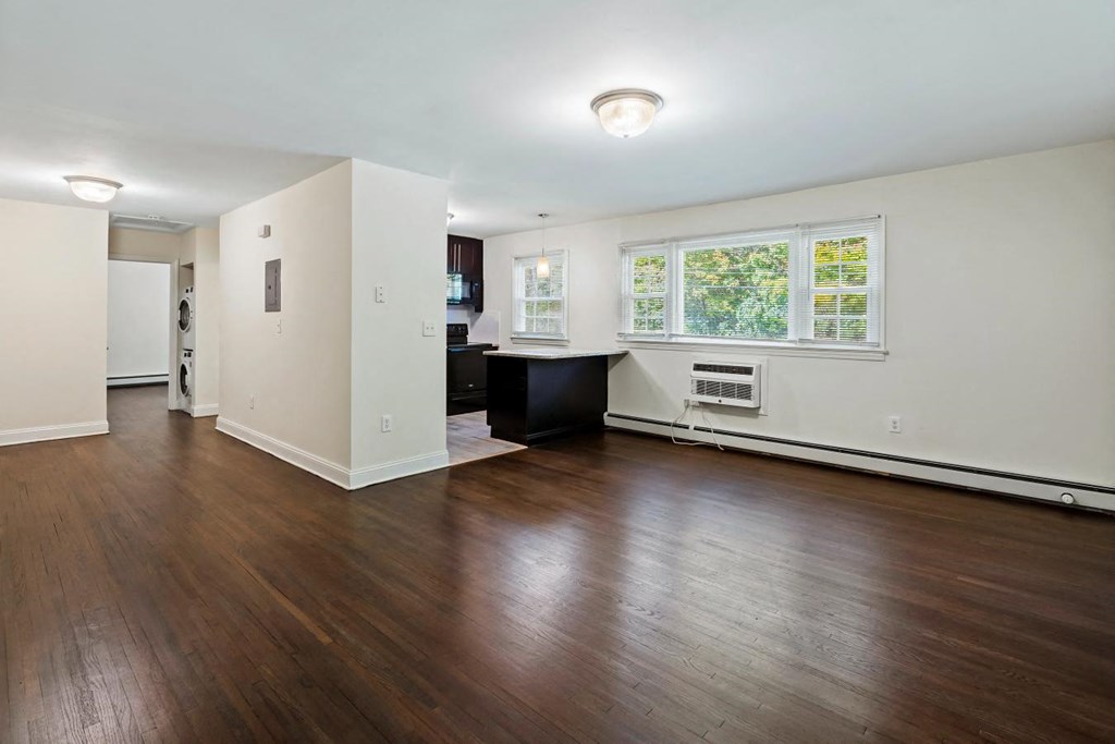 an empty living room with hard wood floors and a window