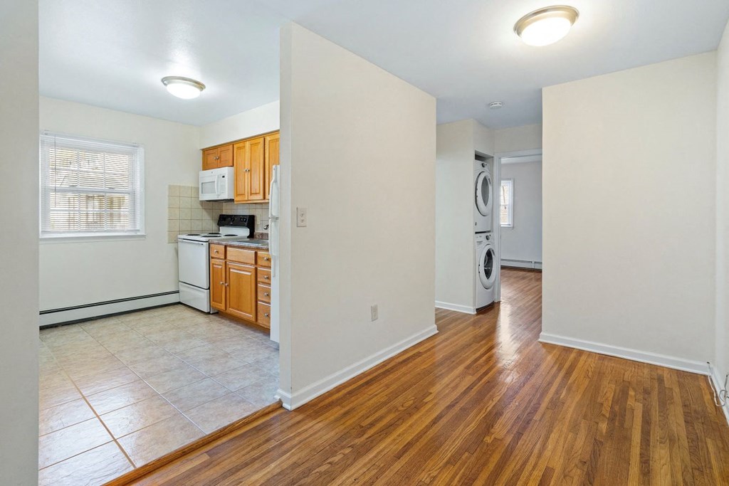 an empty kitchen with wood flooring and white walls