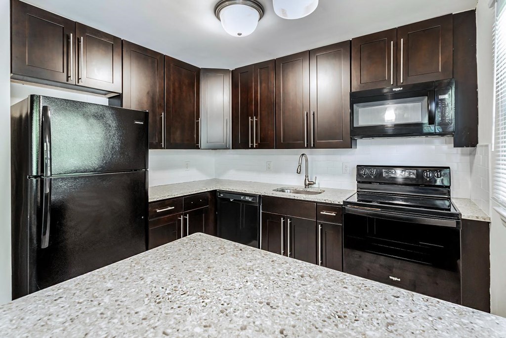 a kitchen with black appliances and granite counter tops