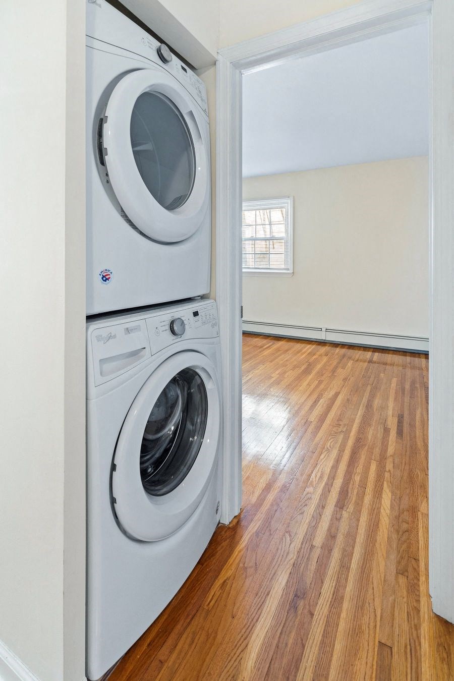 a front loading washer and dryer in a room with a wood floor