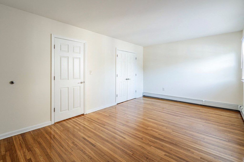 an empty living room with white walls and wood floors