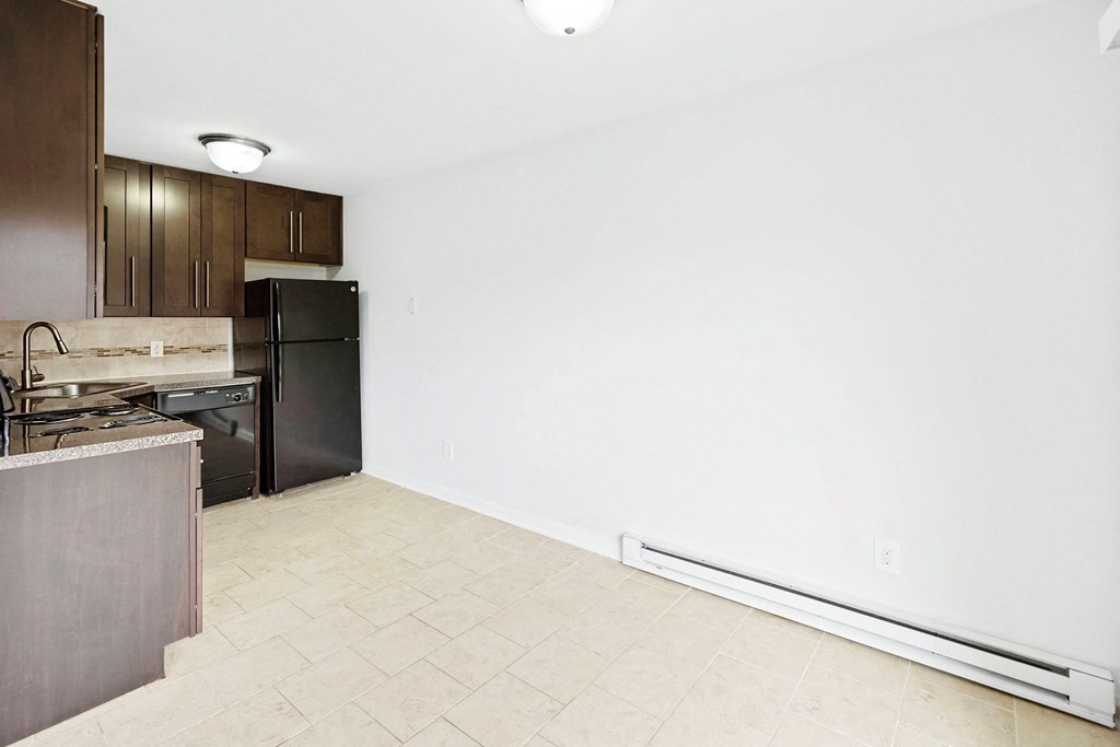 an empty kitchen with a stove and a refrigerator