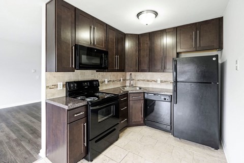 a kitchen with dark wood cabinets and stainless steel appliances