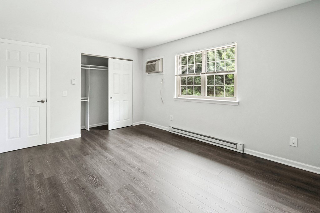 an empty living room with white walls and wood floors