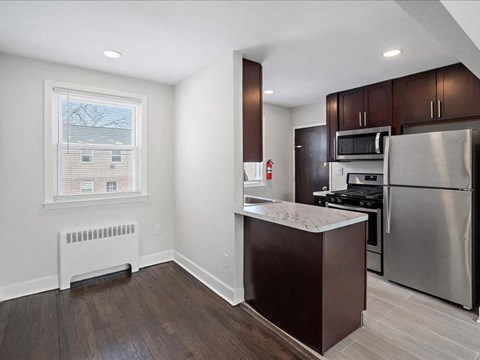 A kitchen with a stainless steel refrigerator and microwave.