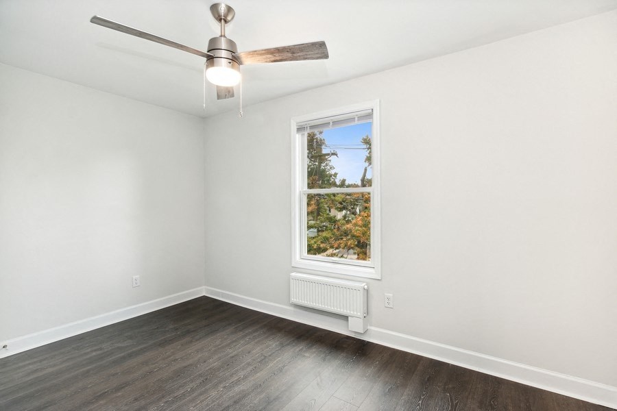 an empty room with a window and a ceiling fan