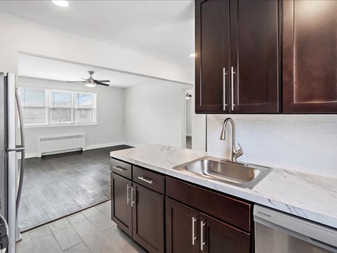 A kitchen with brown cabinets and a marble countertop.