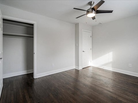 A room with a ceiling fan and a door.
