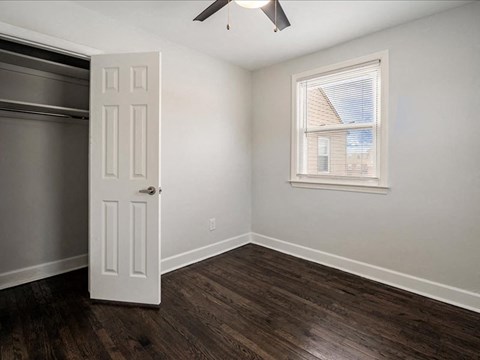 A room with a white door and a window with blinds.