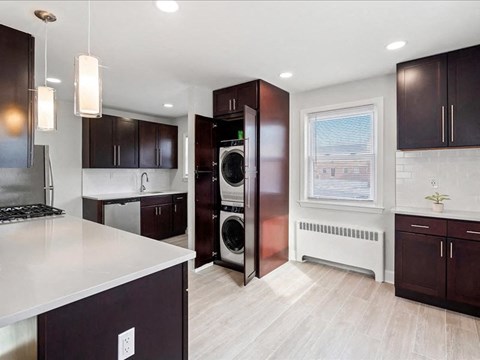 A modern kitchen with dark brown cabinets and a white countertop.