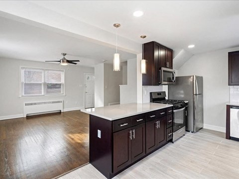 A kitchen with dark wood cabinets and a white countertop.