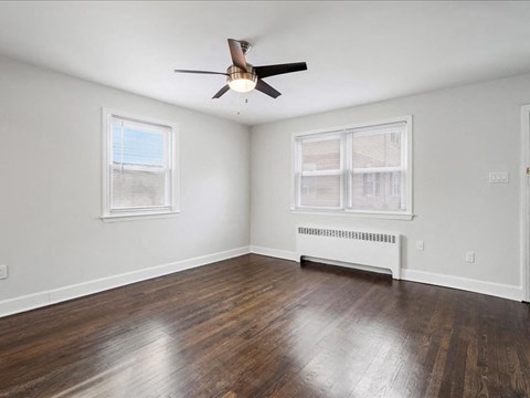 A room with a ceiling fan and a window with blinds.