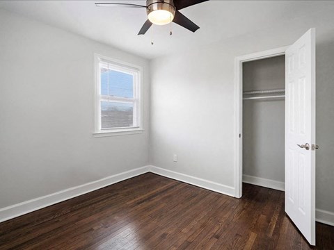 A room with a ceiling fan and a window.