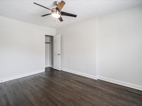 A room with a ceiling fan and a door.