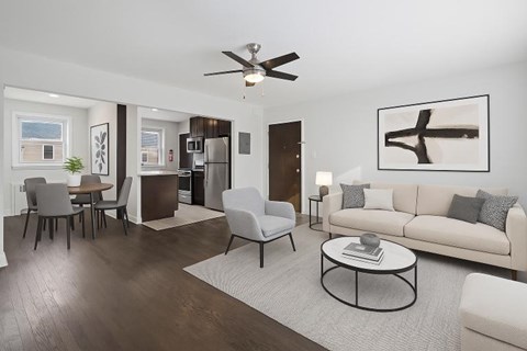 A modern living room with a white couch, a coffee table, and a ceiling fan.