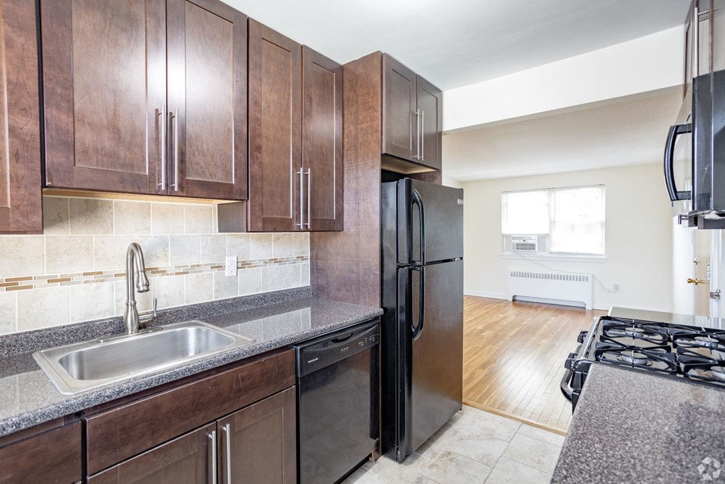 a kitchen with wooden cabinets and a sink and refrigerator