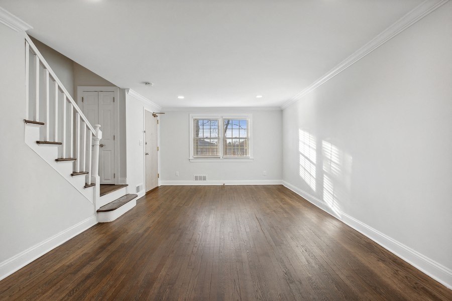 an empty living room with white walls and wood floors