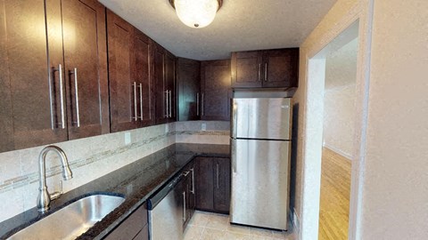 a kitchen with a stainless steel refrigerator and a sink