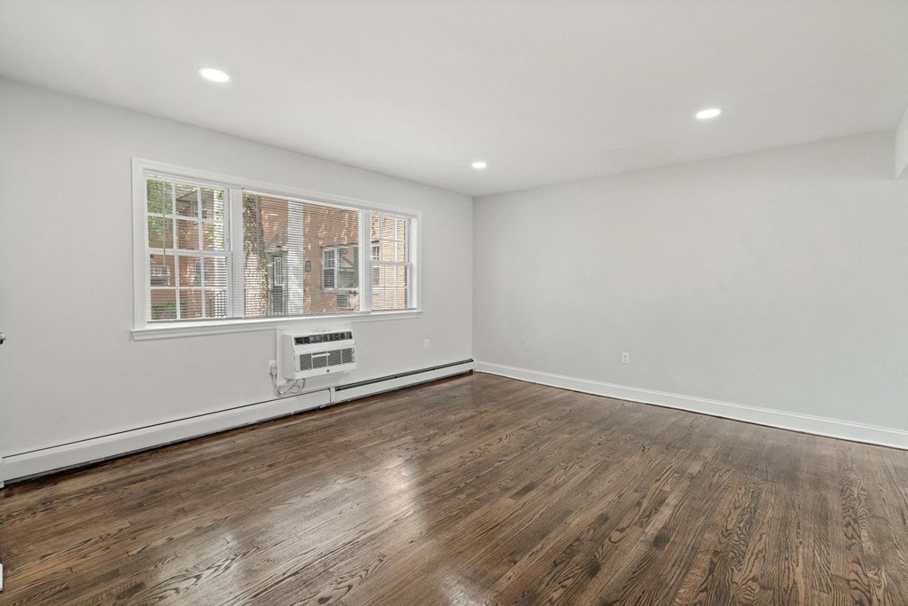 an empty living room with white walls and a window