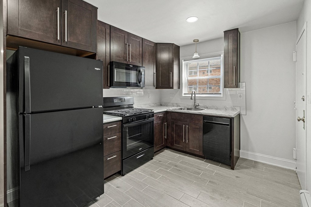 a kitchen with black appliances and dark wood cabinets
