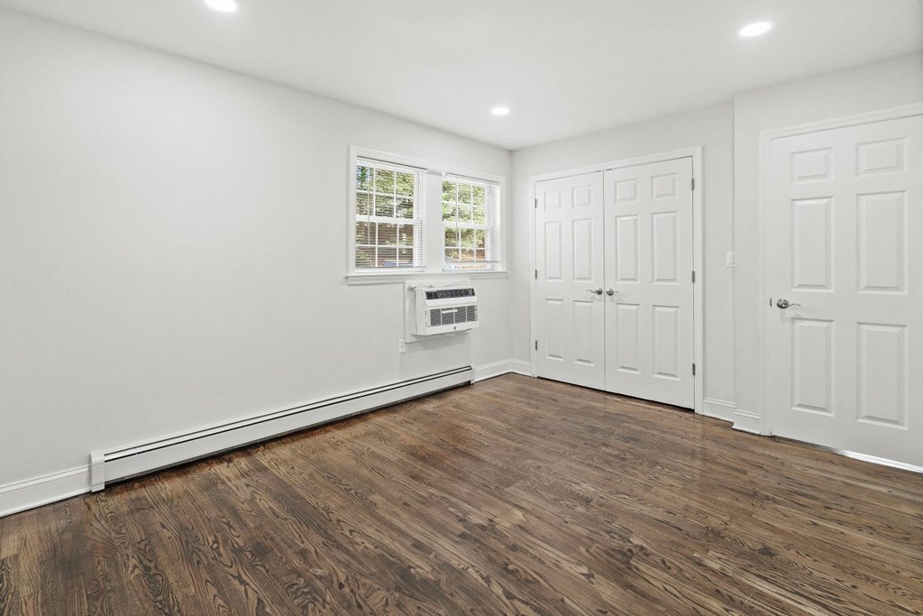 an empty living room with white walls and wood floors