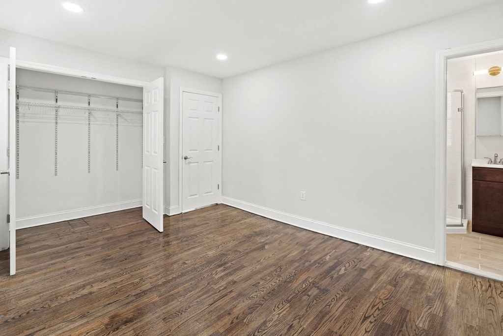an empty bedroom with a closet and a bathroom