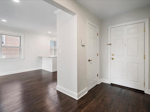 A room with white walls and a wooden floor.
