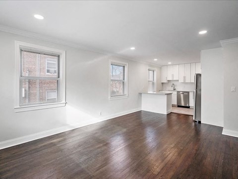 A large empty room with wooden floors and white walls.