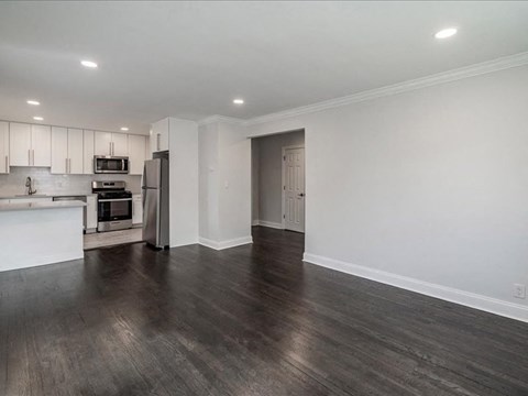 A kitchen with white cabinets and a microwave is visible.