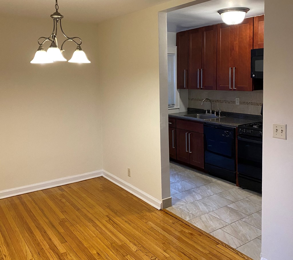 an empty kitchen with wooden floors and wooden cabinets