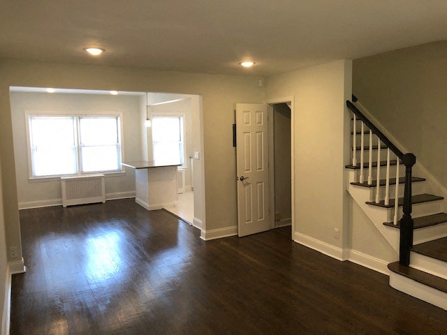 an empty living room with wood floors and a staircase