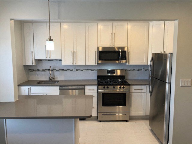 a kitchen with stainless steel appliances and white cabinets