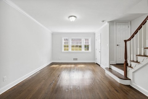 an empty living room with white walls and wood floors