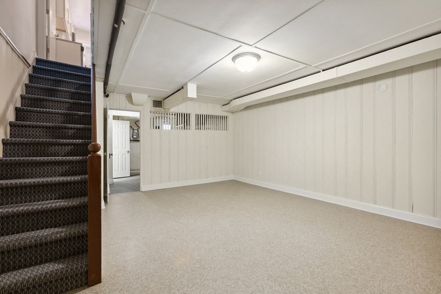 the interior of a basement with a staircase and a carpeted floor